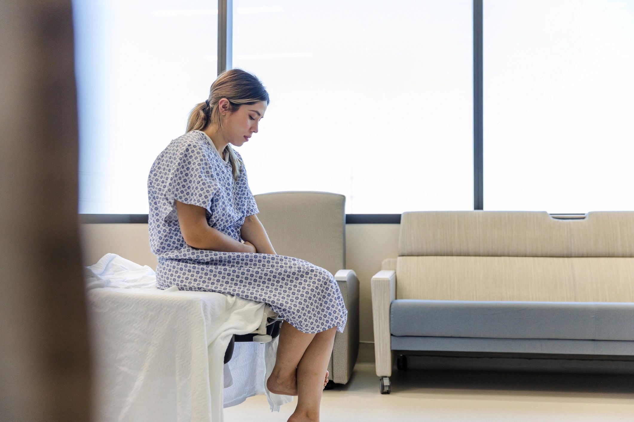 Patient in a hospital gown waiting in a hospital room