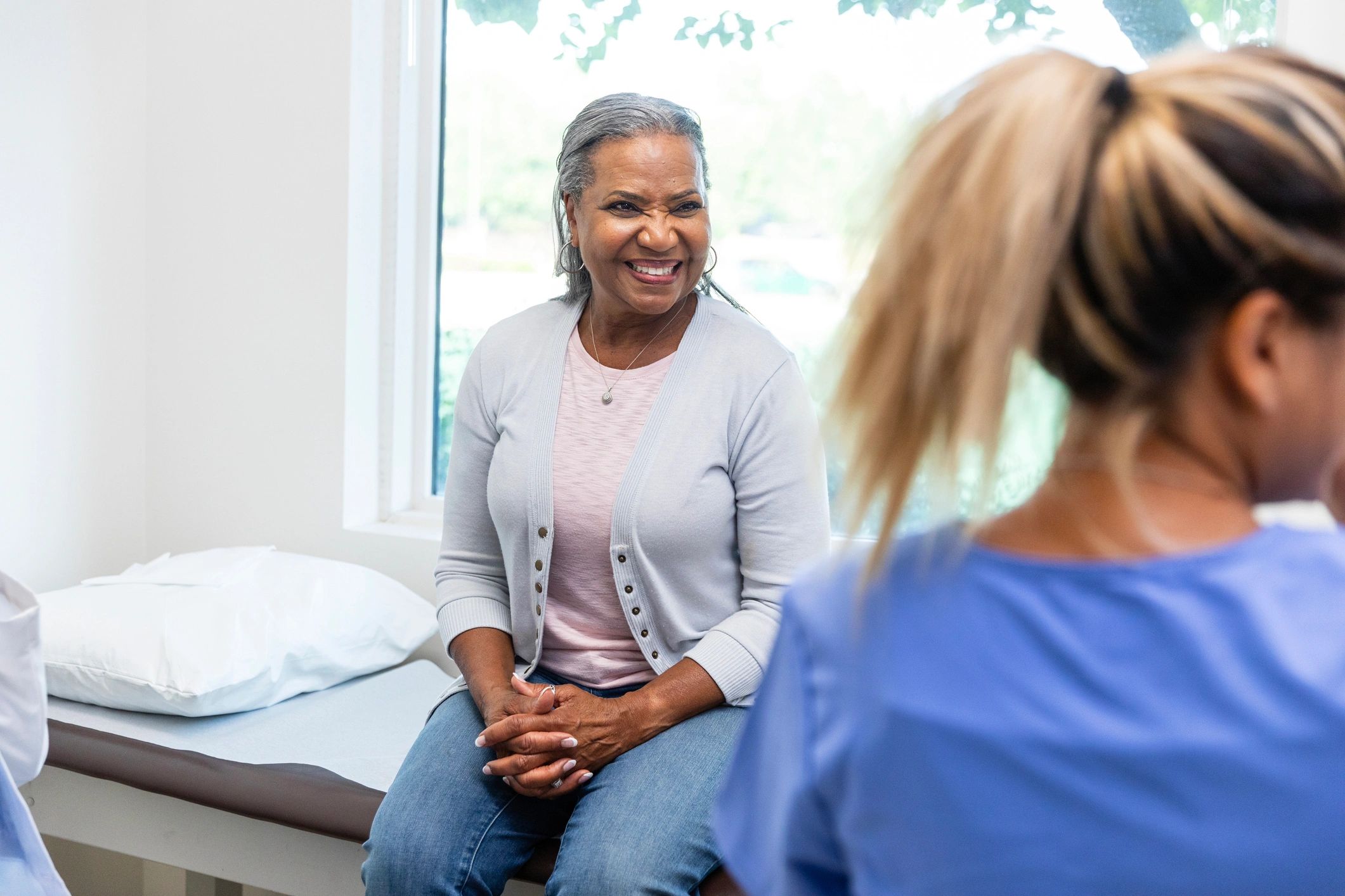 Breast cancer patient smiling while speaking with a nurse