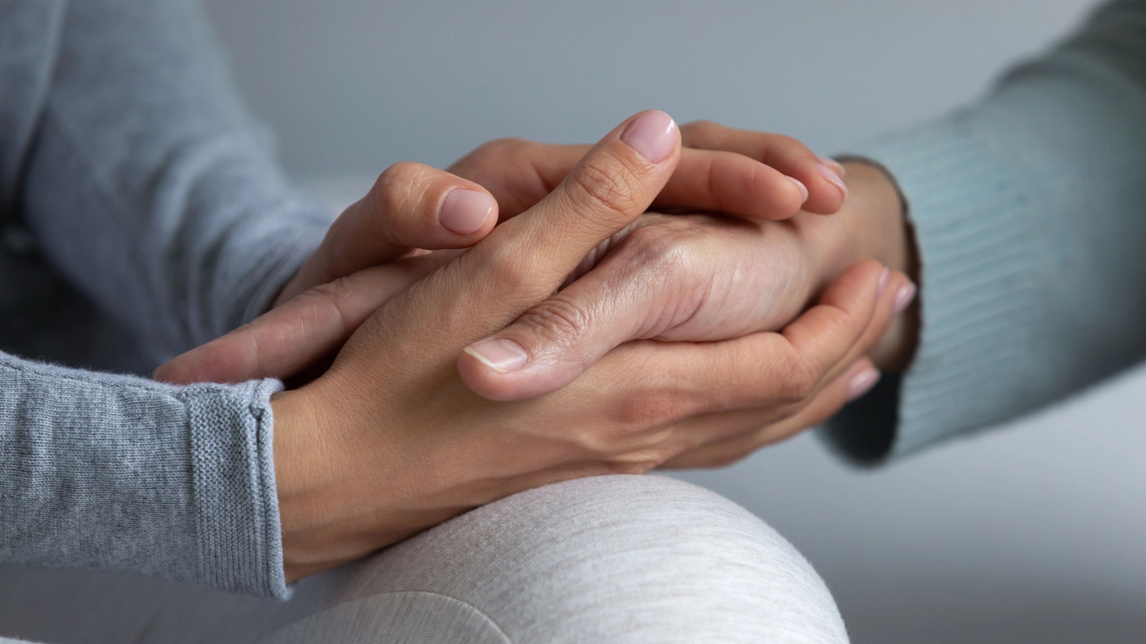 A loved one holding a patient’s hand in support